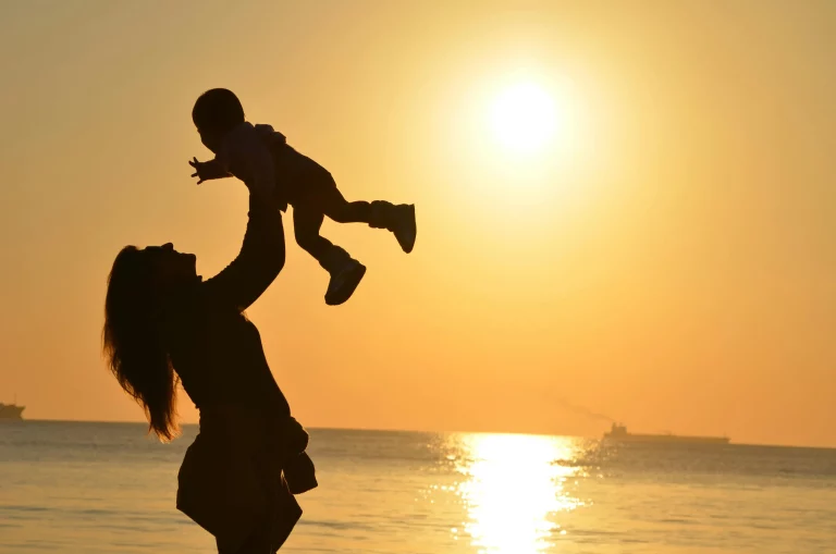 A mother carrying and lifting a child.