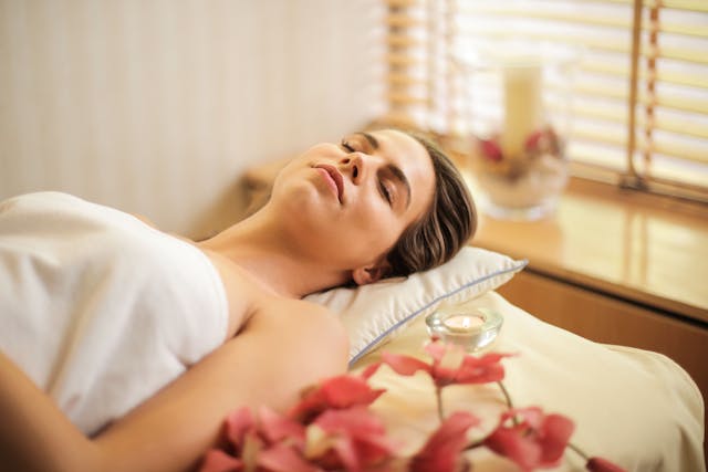 A woman lying with her eyes closed during her spa treatment.